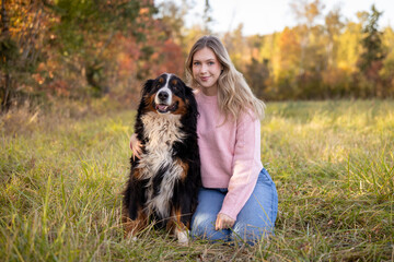 young woman with her dog outside in the fall