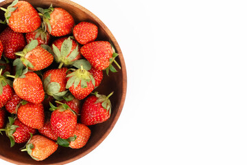 Wooden bowl of strawberries occupies the left side creating a natural frame with ample copy space.