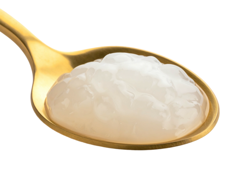 Spoonful of translucent, round pearls rests on golden spoon against a stark black background, highlighting texture