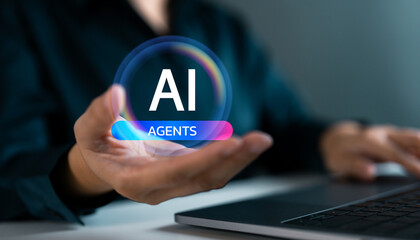 Close-up of hand holding glowing AI Agents icon above laptop. Artificial intelligence, digital assistant, smart automation and future technology in human-computer interaction.