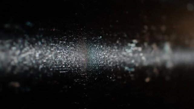 Close-up of a dark, textured surface with specks of light, soft focus and horizontal lines