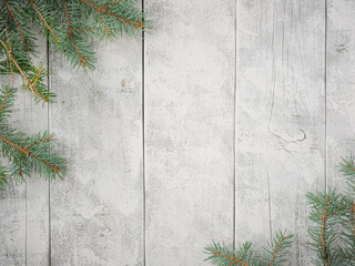 Evergreen pine spruce branch needles greenery on white rustic wood plank table. Winter holiday seasonal overhead flatlay