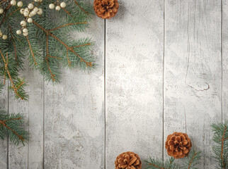 Evergreen pine spruce branch needles greenery pinecones and berries on white rustic wood plank table. Winter festive Christmas holiday seasonal overhead flatlay
