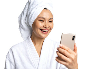 Smiling woman in robe with towel on head video chatting on smartphone against black background