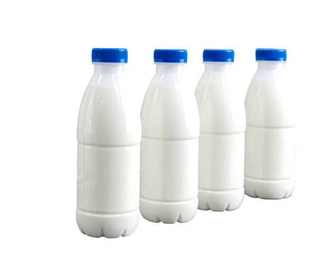Four plastic bottles filled with white liquid, all capped with blue lids, on a black background, in diagonal alignment