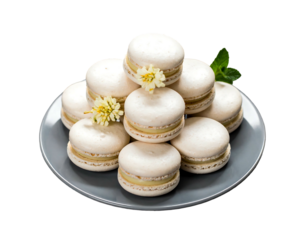 Stack of pale macarons on gray plate, garnished with tiny flowers and mint, against a dark backdrop