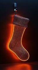 Hanging Christmas stocking illuminated by orange and red neon lights against dark background.