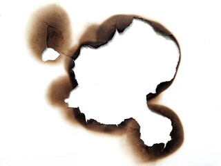 Close up of fire burned hole on white paper background. Burn mark and paper texture with scorched edges. White paper with fire burned hole.