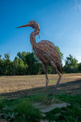 Metal heron sculpture against a blue sky