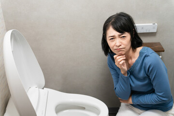 トイレのトラブルで困るミドル女性　ライフスタイルイメージ