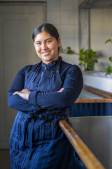 Smiling female chef standing confidently in kitchen