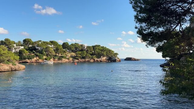clear blue waters and rocky green shores frame the tranquil cove of cala ferrera in mallorca island spain
