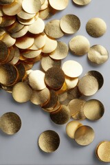 Gleaming gold circles scattered across a smooth gray surface