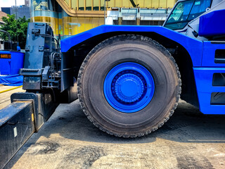 Close-up of a large blue construction vehicle wheel on a jobsite, highlighting heavy-duty machinery, strength, and industrial equipment in use.