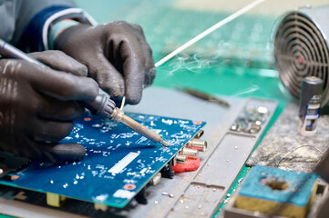 Soldering circuit board components in a workshop during a busy afternoon