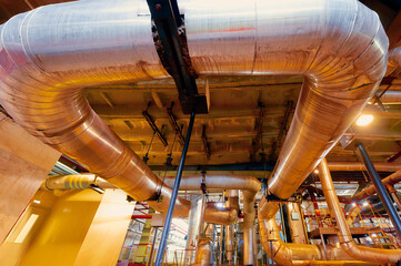 Complex network of metal ducts and pipes at an industrial facility showcasing modern engineering and design
