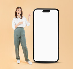 Happy Asian business woman hand touching a large smartphone screen isolated on beige color background, travel concept.