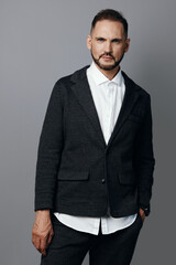 A business professional man stands against a solid colored background, radiating confidence and...