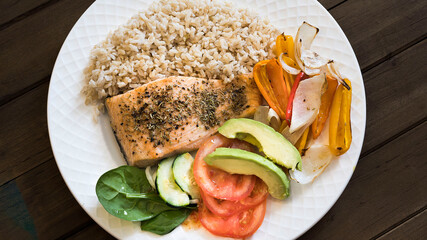 Close up of a grilled salmon fillet with vegetables and whole rice. Meal for lunch