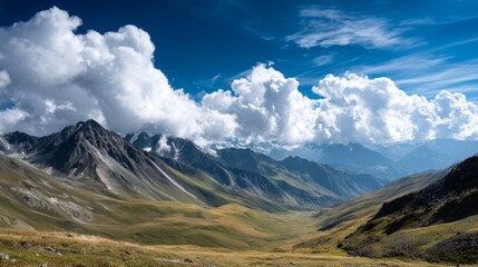 Majestic Mountain Landscape with Rolling Hills and Dramatic Clouds Under a Bright Blue Sky in a Remote Wilderness Area