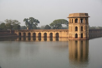 A serene view of the manjusha museums ancient architecture reflected in the tranquil waters of the bindu sagar lake in sirpur, chhattisgarh, india.