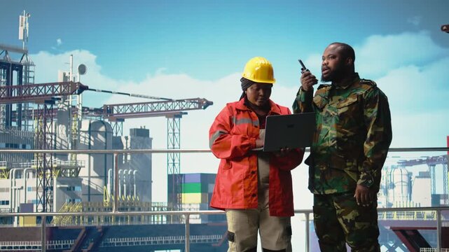 Soldier working on offshore platform issuing command over radio transmission. Military unit boarding drilling barge under maritime interdiction protocol, monitoring perimeter, camera A