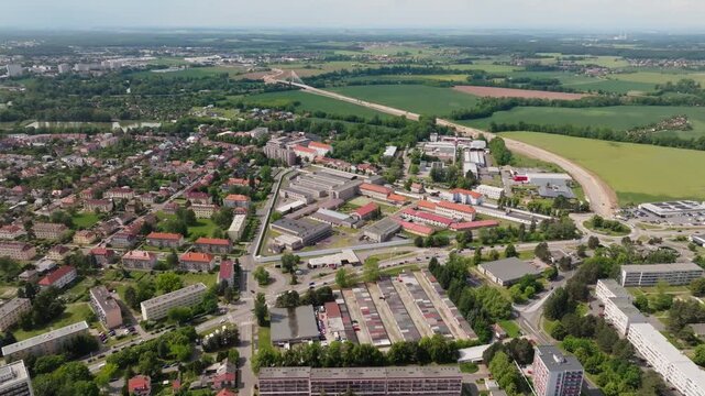Aerial rising reveal from outside the wall to a wide view of the full prison complex; smooth vertical ascent, continuous shot, daytime.
