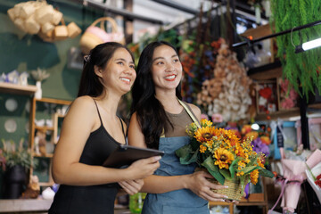 Florist and assistant managing flower shop business