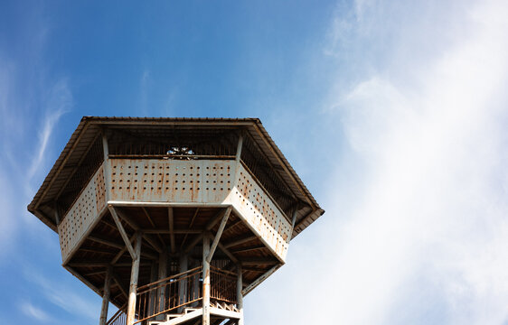 Weathered rusty lighthouse under a clear blue sky