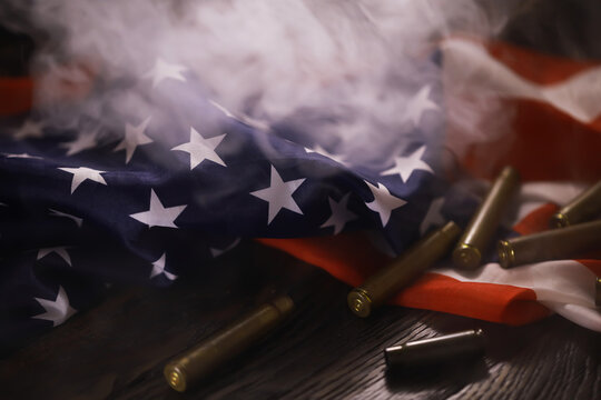 Gun Control Concept Image with American Flag and Bullet Casings in Smoke