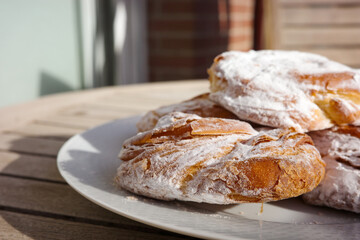 Traditional Spanish ensaimadas with powdered sugar on a plate