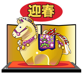 金屏風の背景の前の台座に飾られた午年の郷土玩具