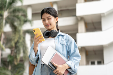 Beautiful student asian woman with backpack and books outdoor. Smile girl happy carrying a lot of book in college campus. Portrait female on international Asia University. Education, study, school