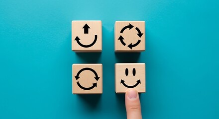 Four wooden blocks with different arrows and a smiley face, representing change and happiness, on a blue background