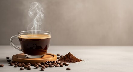 Steaming hot black coffee in a clear glass cup on a wooden coaster with scattered beans and grounds on a light surface.