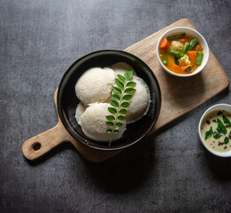 Popular South Indian snacks idli sambar or idly sambhar prepared by steaming fermented rice and served with coconut dip and vegetable soup or sambar. Top view