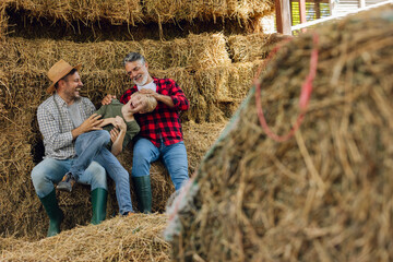 Family generations playing together in hay barn