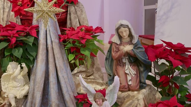 Catholic nativity scene with virgin Mary. Christmas religious still life with red flowers prayer and faith detail closeup