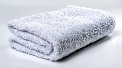 Soft and fluffy white towel folded neatly on a clean surface, ideal for bathroom, spa or hotel settings, showcasing hygiene and comfort for guests and consumers.