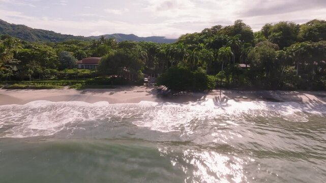 Punta Potrero, Costa Rica with ocean view and mountains with drone video moving in low along beach.