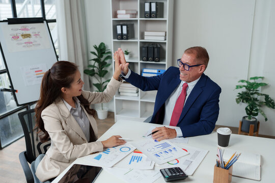 Business team celebrating success with high five in office