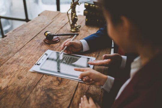 Legal professionals discussing contract using digital tablet