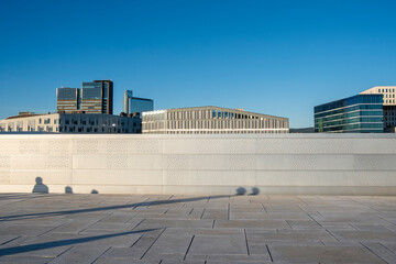 Central urban square with geometric architecture, minimal symmetry, wide perspective, bright copyspace, rhythmic geometry, open space linking city urbanscape streetscape skyline
