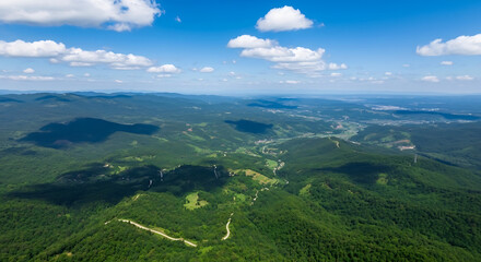 Obraz premium Dahong Mountain Under Blue Sky with Clouds and Vast Green Valleys Featuring a Winding Path Leading to the Horizon 