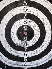 Worn black and white target board with numbers.