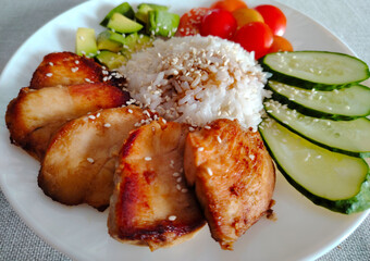 Teriyaki chicken breast with rice and fresh vegetables.