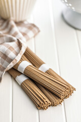Buckwheat soba noodles on white table.