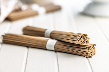 Buckwheat soba noodles on white table.