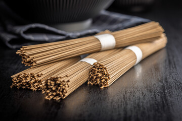 Buckwheat soba noodles on black table.