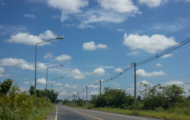 Beautiful daytime view of clouds and sky over a rural Thai road.